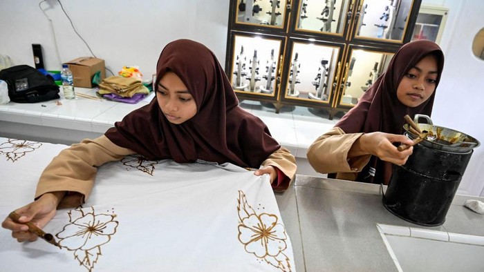 High school students dry batik cloth, a traditional textile made using wax-resist dyeing methods, in Lhoknga, Aceh province on October 1, 2022, on the eve of Indonesia's National Batik Day celebrated on October 2. (Photo by CHAIDEER MAHYUDDIN / AFP) (Photo by CHAIDEER MAHYUDDIN/AFP via Getty Images)