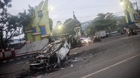 Setidaknya ada tiga mobil yang dilalap kobaran api. Tiga mobil itu adalah dua sedan yang terbakar habis, sementara 1 mobil lagi adalah truk Brimob yang tidak terbakar seluruhnya. Foto: AFP via Getty Images/PUTRI