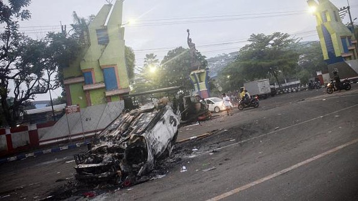Motorists commute outside Kanjuruhan stadium the morning after a football match between Arema FC and Persebaya Surabaya in Malang, East Java on October 2, 2022. - At least 127 people died at a football stadium in Indonesia when fans invaded the pitch and police responded with tear gas, triggering a stampede, authorities said on October 2. (Photo by PUTRI / AFP) (Photo by PUTRI/AFP via Getty Images)