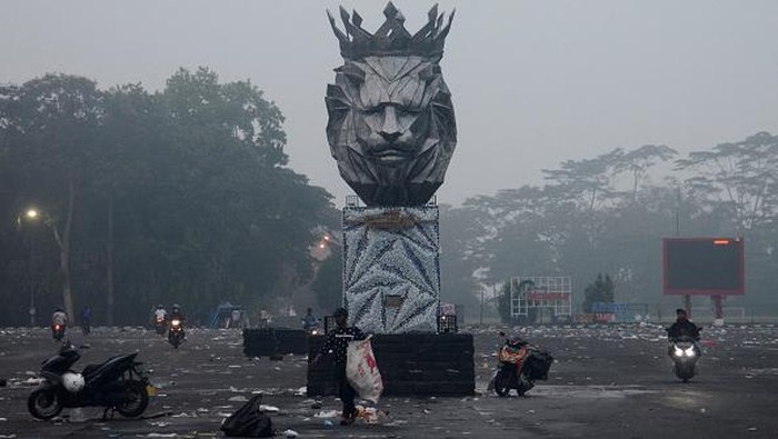 Motorists commute outside Kanjuruhan stadium the morning after a football match between Arema FC and Persebaya Surabaya in Malang, East Java on October 2, 2022. - At least 127 people died at a football stadium in Indonesia when fans invaded the pitch and police responded with tear gas, triggering a stampede, authorities said on October 2. (Photo by PUTRI / AFP) (Photo by PUTRI/AFP via Getty Images)
