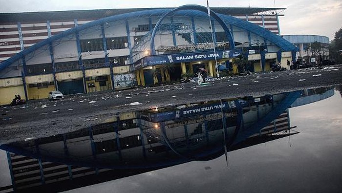 Motorists commute outside Kanjuruhan stadium the morning after a football match between Arema FC and Persebaya Surabaya in Malang, East Java on October 2, 2022. - At least 127 people died at a football stadium in Indonesia when fans invaded the pitch and police responded with tear gas, triggering a stampede, authorities said on October 2. (Photo by PUTRI / AFP) (Photo by PUTRI/AFP via Getty Images)