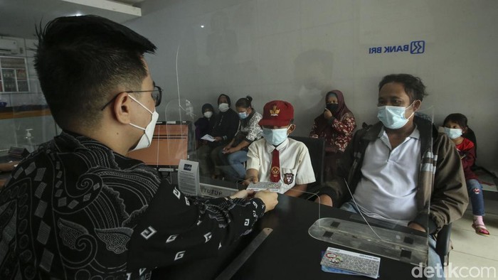 Potret Warga Seluas Cairkan Dana Program Indonesia Pintar Orang tua bersama anaknya mencairkan dana PIP di BRI Unik Seluas, Kalimantan Barat, Senin (5/9/2022). Diketahui dana PIP dapat diambil melalui bank BRI.