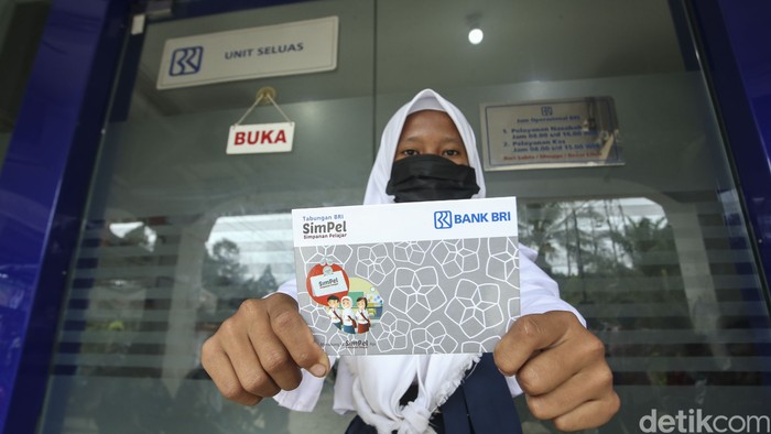 Orang tua bersama anaknya mencairkan dana PIP di BRI Unik Seluas, Kalimantan Barat, Senin (5/9/2022). Diketahui dana PIP dapat diambil melalui bank BRI.