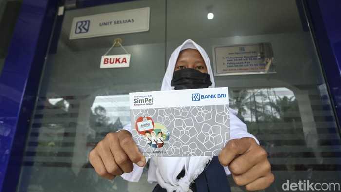 Orang tua bersama anaknya mencairkan dana PIP di BRI Unik Seluas, Kalimantan Barat, Senin (5/9/2022). Diketahui dana PIP dapat diambil melalui bank BRI.