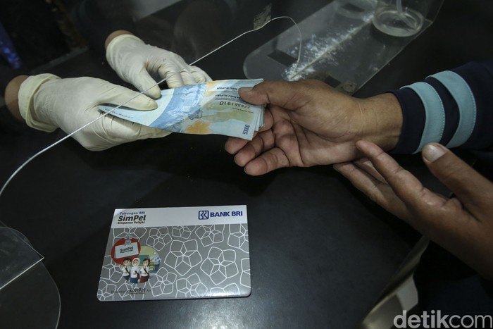 Orang tua bersama anaknya mencairkan dana PIP di BRI Unik Seluas, Kalimantan Barat, Senin (5/9/2022). Diketahui dana PIP dapat diambil melalui bank BRI.