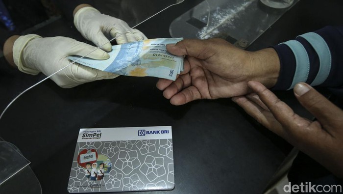 Orang tua bersama anaknya mencairkan dana PIP di BRI Unik Seluas, Kalimantan Barat, Senin (5/9/2022). Diketahui dana PIP dapat diambil melalui bank BRI.