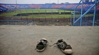 Sepasang sepatu yang terinjak-injak tampak di tribun Stadion Kanjuruhan, Malang, Minggu (2/10/2022). Foto: AP/Hendra Permana
