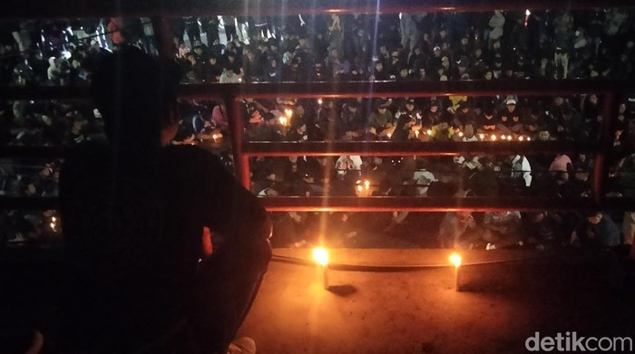 Suporter Arema FC menyalakan lilin keprihatinan atas tragedi Kanjuruhan di Stadion Gajayana Malang