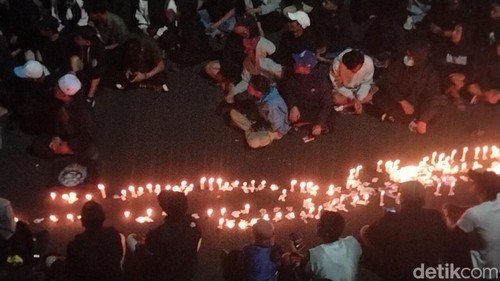 Suporter Arema FC menyalakan lilin keprihatinan atas tragedi Kanjuruhan di Stadion Gajayana Malang