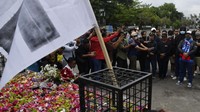 Suporter Arema FC (Aremania) berdoa di Patung Singa Stadion Kanjuruhan, Malang, jawa Timur, Minggu (2/10/2022).