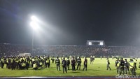 Petugas berusaha menghalau ribuan suporter yang turun ke lapangan/Foto: M Bagus Ibrahim/detikJatim