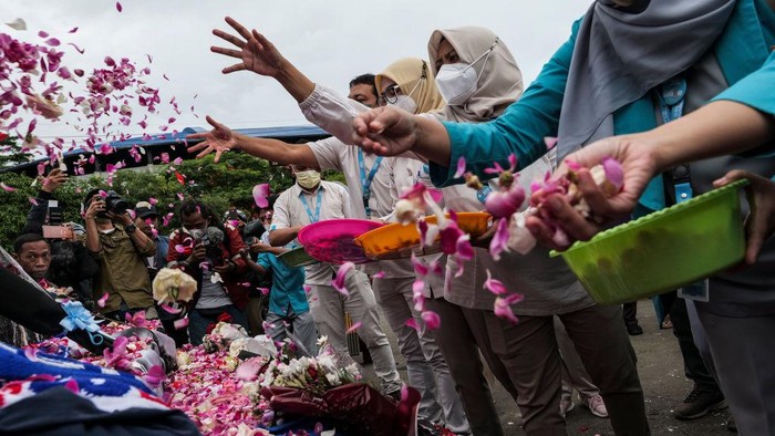 Aksi Warga Tabur Bunga di Patung Singa Kanjuruhan MALANG, INDONESIA - OCTOBER 03: Supporters and people lay flowers as they pay condolence to the victims outside Kanjuruhan Stadium on October 03, 2022 in Malang, Indonesia. A riot and stampede broke out at a football stadium in East Java on Saturday. Police fired tear gas to disperse fans who had invaded the pitch after and began fighting the match ended. A stampede for the exits has resulted in at least 125, media reports said, with many still injured in hospitals. (Photo by Ulet Ifansasti/Getty Images)