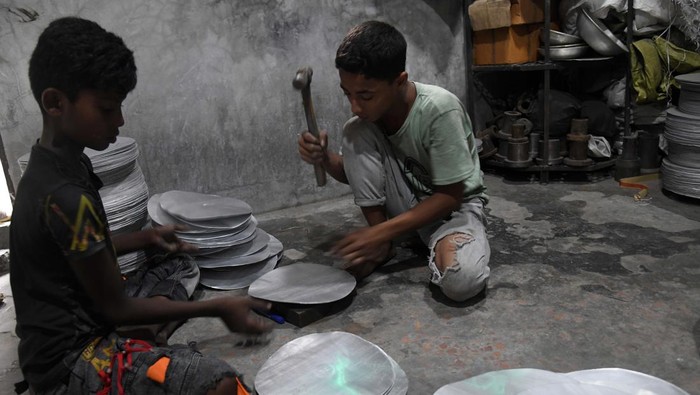 Anak Kecil Banting Tulang di Pabrik Aluminium Ini From left Shofiul (13) and Akash (13), during work at a aluminium factory as they earn less than USD 10 in a week in Dhaka, Bangladesh on September 30, 2022. Bangladesh made moderate advancements last year in efforts to eliminate the worst forms of child labour, according to a report of the US Department of Labor published on Wednesday. (Photo by Syed Mahamudur Rahman/NurPhoto via Getty Images)