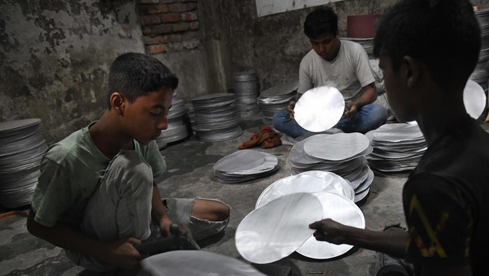 Anak Kecil Banting Tulang di Pabrik Aluminium Ini From left Shofiul (13) and Akash (13), during work at a aluminium factory as they earn less than USD 10 in a week in Dhaka, Bangladesh on September 30, 2022. Bangladesh made moderate advancements last year in efforts to eliminate the worst forms of child labour, according to a report of the US Department of Labor published on Wednesday. (Photo by Syed Mahamudur Rahman/NurPhoto via Getty Images)