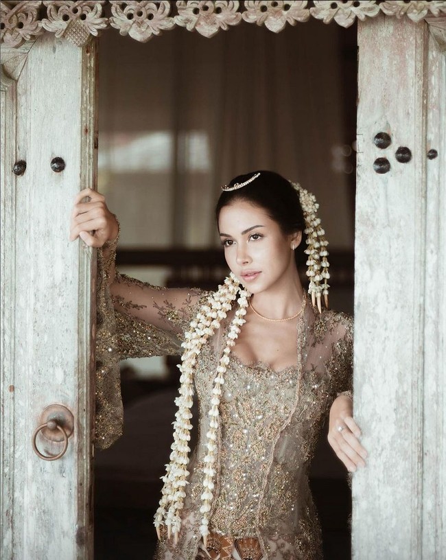 Wanita berdarah campuran Indonesia-Belanda ini memilih perhiasan bergaya minimalis untuk anting, kalung dan tiara yang disematkan pada bagian depan sanggul. Foto: Instagram @estelleelinden @thebridestory