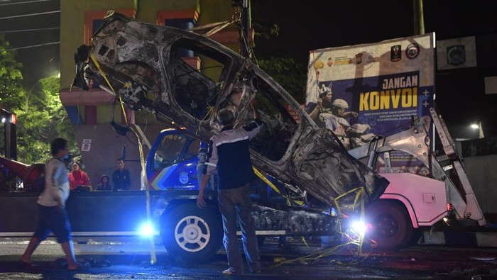Polisi mengevakuasi mobil yang rusak akibat kerusuhan di lapangan Stadion Kanjuruhan, Malang, Jawa Timur, Minggu (2/10/2022). Kerusuhan yang terjadi di stadion tersebut menyebabkan 13 unit mobil rusak, 10 unit diantaranya mobil polisi dan tiga unit mobil pribadi. ANTARA FOTO/Zabur Karuru/nym.