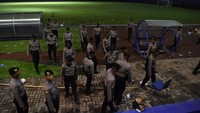 Sejumlah polisi melintas di pinggir lapangan Stadion Kanjuruhan, Malang, Jawa Timur, Minggu (2/10/2022).