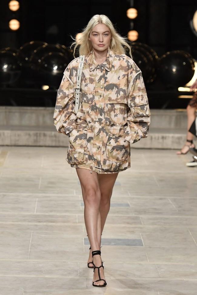 Inilah penampilan Gigi Hadid di fashion show Isabel Marant. Model 27 tahun itu mengenakan camo-print jacket atau dress. Penampilannya memesona dengan makeup flawless. Foto: Dok. Getty Images