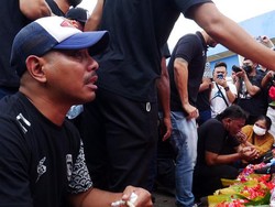 Mereka melakukan tabur bunga disertai doa bersama di patung Singa Tegar yang berada di luar stadion. Tangis pecah saat itu, hampir semua tak kuasa menahan air mata. Foto: (Dasril Roszandi/Getty Images)
