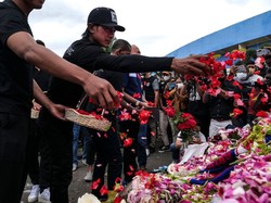 Kapten tim Johan Alfarizi (kiri) tampak emosional begitu menaburkan bunga di luar stadion Kanjuruhan. Foto: (Getty Images/Ulet Ifansasti)