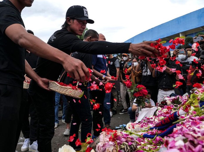 Kapten tim Arema FC Johan Alfarizi menabur bunga di luar Stadion Kanjuruhan, Malang, Jawa Timur, Senin (3/9/2022).