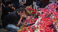 Pemain dan ofisial Arema FC berkumpul untuk berdoa di taburan bunga di luar Stadion Kanjuruhan, Malang, Jawa Timur, Senin (3/9/2022). Foto: Juni Kriswanto/AFP/Getty Images