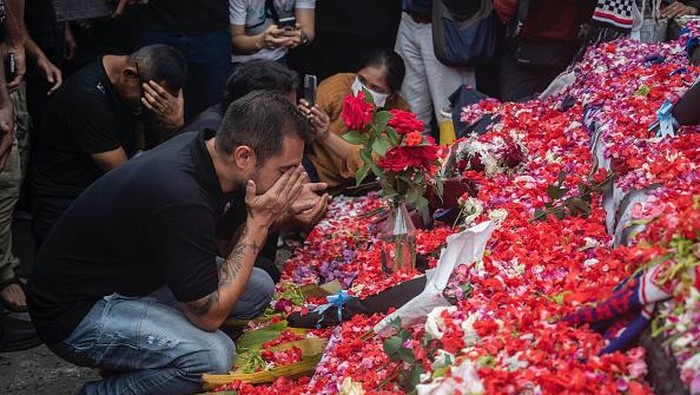 Pemain dan ofisial Arema FC berkumpul untuk berdoa di taburan bunga di luar Stadion Kanjuruhan, Malang, Jawa Timur, Senin (3/9/2022).