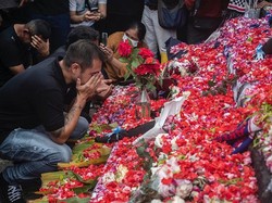 Pemain dan ofisial Arema FC berkumpul untuk berdoa di taburan bunga di luar Stadion Kanjuruhan, Malang, Jawa Timur, Senin (3/9/2022). Foto: Juni Kriswanto/AFP/Getty Images