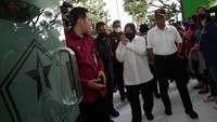 Menko PMK Muhadjir Effendi (Kanan) bersama Mensos Tri Rismaharini menyapa warga saat penyerahan bansos di Kantor Kecamatan Lowokwaru, Kota Malang, Jawa Timur, Senin (3/10/2022).