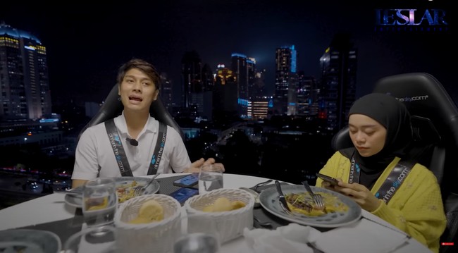 Dalam video, Lesti memang terlihat tidak terlalu banyak berbicara. Sesekali ia tampak mengecek ponselnya usai menyantap hidangan yang ada di depannya. Foto: YouTube/Leslar Entertainment