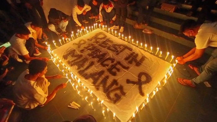 Para suporter sepakbola di Bandar Lampung menyalakan lilin disekitar spanduk bertuliskan 