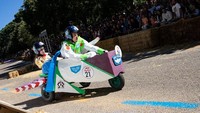 Peserta mengendarai mobil tanpa mesinnya di jalan selama perlombaan kotak sabun Red Bull Autos Locos di Madrid, Spanyol, Minggu (2/10/2022) waktu setempat.  