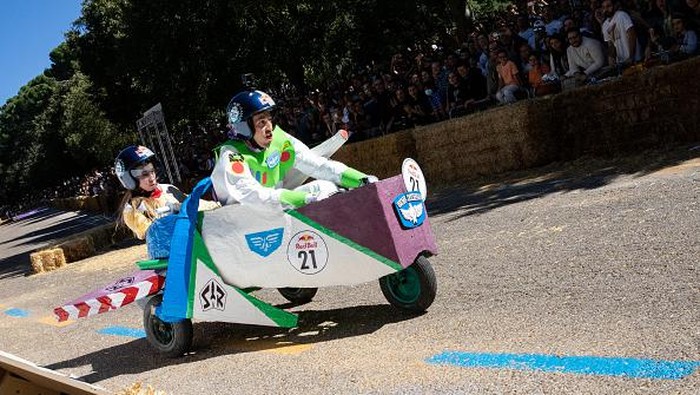 Peserta mengendarai mobil tanpa mesinnya di jalan selama perlombaan kotak sabun Red Bull Autos Locos di Madrid, Spanyol, Minggu (2/10/2022) waktu setempat.