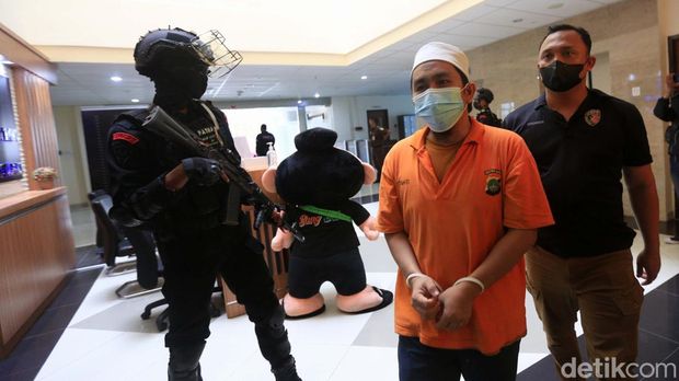 Sepuluh orang tersangka kasus Khilafatul Muslimin diserahkan ke Kejari Bekasi. Polisi bersenjata laras panjang mengawal proses penyerahan para tersangka.