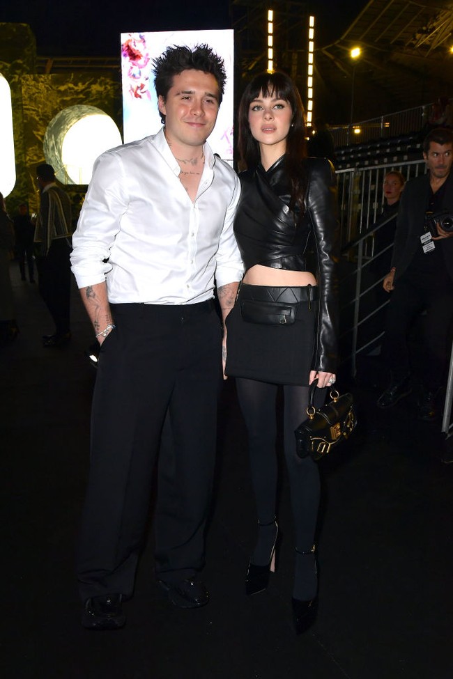 Sebelumnya, pasangan muda itu hadir di fashion show Balmain. Nicola tampil edgy dengan crop top kulit, rok mini dan stocking. Gaya serba hitamnya itu kontras dengan suaminya yang memilih menggunakan kemeja putih.Foto: Getty Images