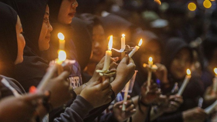 SEMARANG, INDONESIA - OCTOBER 2: Football supporters gather and pray and light candles as a tribute to the victims of the riots in a soccer match at the Jatidiri Stadium in Semarang, Central Java Province, Indonesia on October 2, 2022. According to government officials, at least 174 people including police officers were killed mostly in stampedes after riots following a soccer match between Persebaya Surabaya and Arema Malang at Kanjuruhan Stadium in Malang, Indonesia on October 1, 2022. (Photo by WF Sihardian/Anadolu Agency via Getty Images)