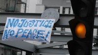 Sebuah spanduk bertuliskan No Justice, No Peace! ini dipasang dekat lampu lalu lintas Jalan Sukarno Hatta, Malang. (Antara Foto/Ari Bowo Sucipto)