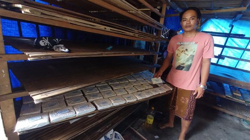 Syamsul (35) menunjukkan tempe yang sedang dianginkan dan siap untuk dijual ke pasar, Senin (3/10/2022). (chairul amri simabur/detikBali)