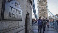 Pengunjung berjalan melintasi Tower Bridge di London, Inggris, Minggu (2/10/2022).