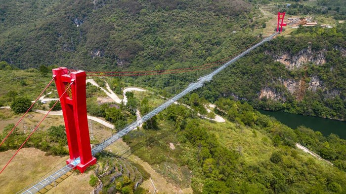 1243565037 QINGYUAN,CHINA - SEPTEMBER 23: An aerial view of the Qingtian Glass Bridge on September 23, 2022 in Qingyuan, Guangdong Province of China.The Qingtian Glass Bridge took three years and cost 300 million yuan to build. It was completed and put into operation in January 2020. With a total length of 526.14 meters, it became the