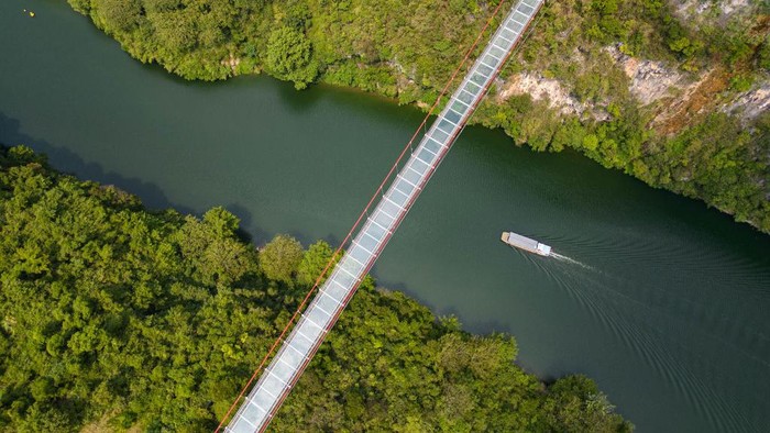 1243565037 QINGYUAN,CHINA - SEPTEMBER 23: An aerial view of the Qingtian Glass Bridge on September 23, 2022 in Qingyuan, Guangdong Province of China.The Qingtian Glass Bridge took three years and cost 300 million yuan to build. It was completed and put into operation in January 2020. With a total length of 526.14 meters, it became the