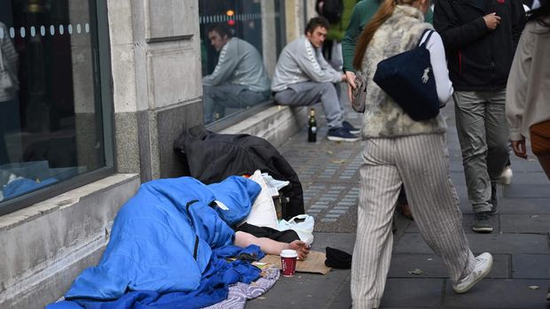 A homeless person sleeps in a sleeping bag on The Strand in central London on October 1, 2022, as campaigners gather in the city to protest against the cost of living crisis. (Photo by Justin TALLIS / AFP) (Photo by JUSTIN TALLIS/AFP via Getty Images)