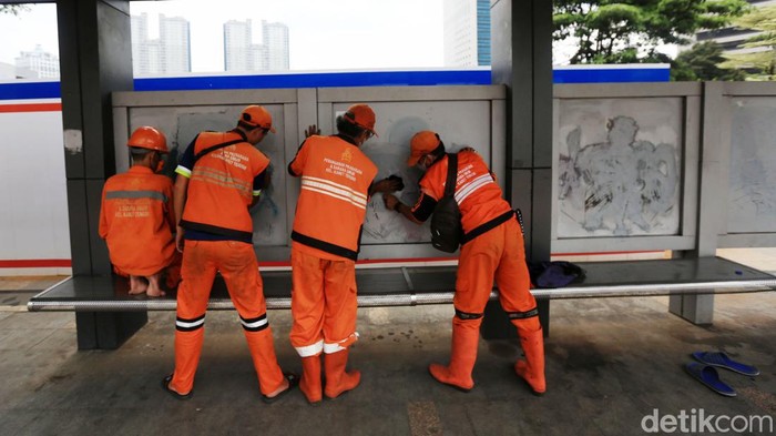 Petugas Penanganan Prasarana dan Sarana Umum (PPSU) membersihkan coretan vandalisme di Halte Dukuh Atas, Jakarta, Selasa (4/10/2022). Hal itu dilakukan agar tidak mengganggu pemandangan dan kebersihan kota. Petugas dengan menggunakan bensin menghapus coretan tersebut. Aksi vandalisme ini dilakulan oleh orang tidak bertanggung jawab di malam hari sebelumnya.