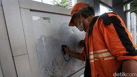 Petugas Penanganan Prasarana dan Sarana Umum (PPSU) membersihkan coretan vandalisme di Halte Dukuh Atas, Jakarta, Selasa (4/10/2022).