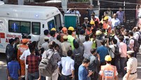 Mayat pekerja yang tertimpa reruntuhan tersebut dibawa ke mobil ambulans. Terlihat warga dan media yang memenuhi area ambulans.