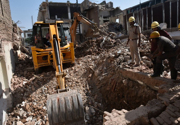 Sebuah mobil excavator menggali reruntuhan bangunan tua yang roboh saat sedang dihancurkan di Gurgaons Udyog Vihar Tahap I, Gurugram, India, Senin (3/10/2022). Pekerjaan pembongkaran ini berlangsung selama lebih dari sebulan.