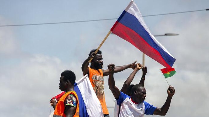 Supporters of Capt. Ibrahim Traore wave Russian flags as they cheered in the streets of Ouagadougou, Burkina Faso, Sunday, Oct. 2, 2022. Burkina Faso's new junta leadership is calling for calm after the French Embassy and other buildings were attacked. (AP Photo/Kilaye Bationo)
