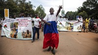 Para pemuda meneriakkan slogan-slogan menentang kekuatan Letnan Kolonel Damiba, melawan Prancis dan pro-Rusia, di Ouagadougou. Kudeta berlangsung ketika perpecahan terus meluas di dalam militer Burkina Faso. Banyak anggota senior militer yang kini berupaya mencari dukungan Rusia menyusul pengaruh bekas kekuasaan kolonial Prancis berkurang di negara tersebut. AP/Sophie Garcia