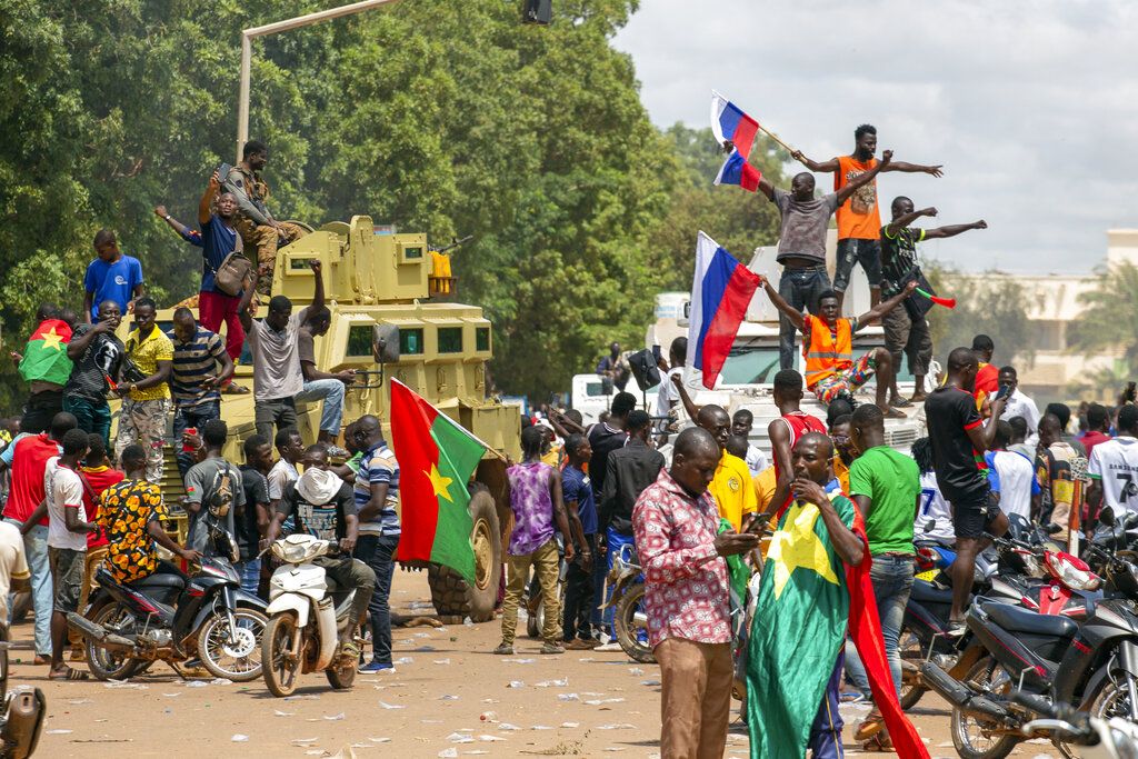 Supporters of Capt. Ibrahim Traore cheer with Russian flags in the streets of Ouagadougou, Burkina Faso, Sunday, Oct. 2, 2022. Burkina Faso's new junta leadership is calling for calm after the French Embassy and other buildings were attacked. (AP Photo/Kilaye Bationo)