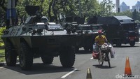 Seorang pedagang bersepeda melintasi alutsista yang dipajang jelang HUT TNI di Jalan Merdeka Utara, Jakarta, Selasa (4/10/2022). Kasetpres menjelaskan bahwa peringatan HUT ke-77 TNI ini juga akan dimeriahkan dengan defile pasukan TNI dan alat utama sistem persenjataan (alutsista).   